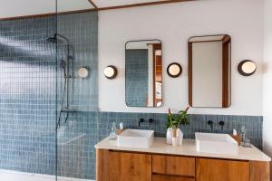a bathroom with two sinks and a shower at Grün Resort Uluwatu in Uluwatu