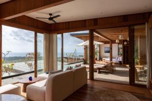 a living room with sliding glass doors and a view of the ocean at Grün Resort Uluwatu in Uluwatu