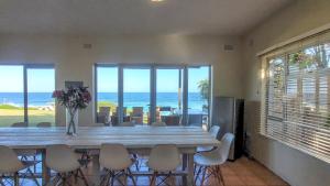 a dining room with a table and chairs and the ocean at Salties Beach House KwaZulu-Natal in Sheffield Beach