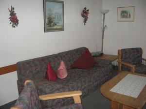 un salon avec un canapé et une table dans l'établissement Ferienhaus Nr 124, Kategorie Economy, Feriendorf Hochbergle, Allgäu, à Karlsebene
