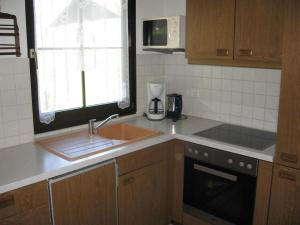 une cuisine avec un évier et un plan de travail dans l'établissement Ferienhaus Nr 124, Kategorie Economy, Feriendorf Hochbergle, Allgäu, à Karlsebene