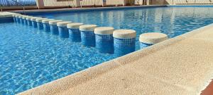a swimming pool with blue and white pillars in the water at Casa Altaona in Sucina