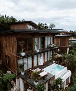 a house with a deck and a swimming pool at Grün Resort Uluwatu in Uluwatu