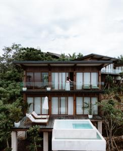 a bride and groom standing on the balcony of a house at Grün Resort Uluwatu in Uluwatu