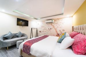 a bedroom with a bed and a tv and a couch at Collection O District Tan Binh Near Airport Formerly Joy Inn in Ho Chi Minh City +43 photos