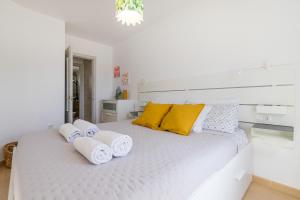 een witte slaapkamer met een groot wit bed met handdoeken erop bij La Preciosa Suite Apartment in Antigua