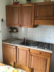 a kitchen with wooden cabinets and a stove top oven at Casa Marmo in Fenestrelle +9 photos