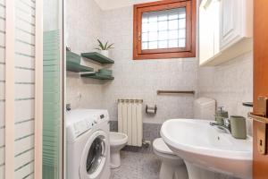 Un baño con lavadora y lavabo. en La Casina di Bree, en Mira