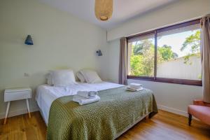 a bedroom with a bed with towels on it at Villa de la Source in Arcachon