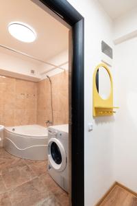 une salle de bain avec baignoire et machine à laver dans l'établissement The Shiny Apple, à Dobroeşti