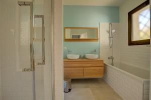 a bathroom with two sinks and a glass shower at Villa de la Source in Arcachon