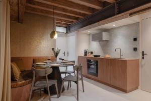 a kitchen and dining room with a table and chairs at MiHotel - Grenier à Sel de Pérouges in Pérouges