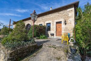 a brick house with a wooden door and a street light at Petit Gite De La Renaissante in Peyrins