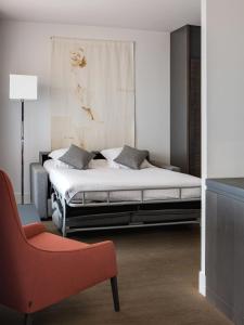 a bedroom with a bed and a red chair at New Hotel of Marseille - Vieux Port in Marseille
