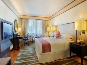 a hotel room with a large bed and a desk at PARKROYAL Yangon in Yangon