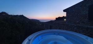 a bath tub in front of a building with the sunset at Roccette OndaTURCHESE, Vista Mare e Jacuzzi Privata in Costa Paradiso