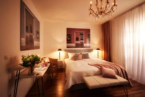 a bedroom with a bed and a chandelier at Remise Heiliger See in Potsdam +17 photos