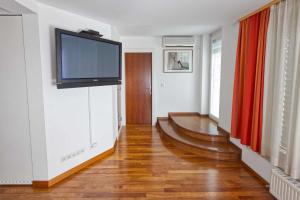 a living room with a flat screen tv on a wall at Hotel Creina in Kranj