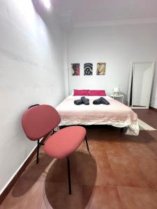 a bedroom with a bed and two red chairs at El Rincón de Pancho in Guía de Isora