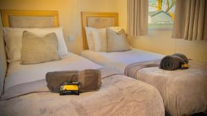 two beds in a hotel room with towels on them at Marton Mere - 3 Bedroom Caravan in Blackpool