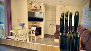 a living room with a table and a couch and a television at Marton Mere - 3 Bedroom Caravan in Blackpool