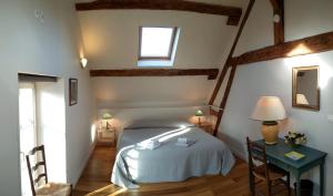a bedroom with a bed and a table and a window at Les Marronniers in Baron