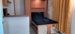 a small bed in a room with a curtain at Studio Appartement Quartier Musée du Louvre 3 Free Netflix in Paris