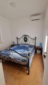 ein Schlafzimmer mit einem Bett mit einer blauen Bettdecke in der Unterkunft Casa Emma in San Nicola Arcella