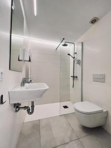 a white bathroom with a sink and a toilet at Hostal by El Collell TODO INCLUIDO in Sant Ferriol