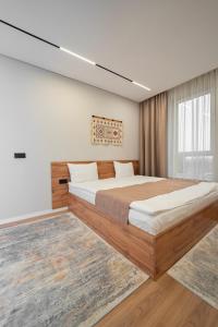 a bedroom with a large bed and a window at Q Apartment in Almaty