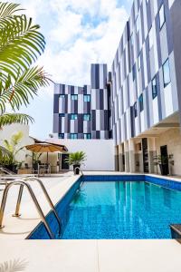 a swimming pool in front of a building at Zind Naaba Hotel in Lomé