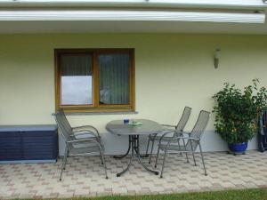 een tafel en stoelen op een patio met een raam bij Ferienwohnung Bohnert in Fischerbach