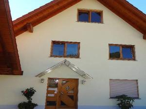 een wit huis met een deur en vier ramen bij Ferienwohnung Bohnert in Fischerbach