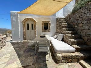 a bed and a table and chairs on a stone wall at 19th Century Vaulted Villa in Kythira +8 photos
