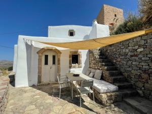 a patio with a table and chairs in front of a building at 19th Century Vaulted Villa in Kythira