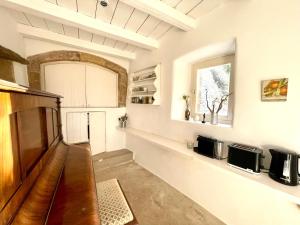 a kitchen with a wooden table and a window at 19th Century Vaulted Villa in Kythira