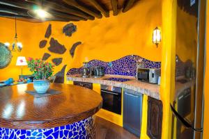 a kitchen with yellow walls and a wooden counter top at CONCHA - Sonnenbett, Sauna, traumhafter Meerblick, beheizter Pool, Billiard, Tischtennis in La Asomada