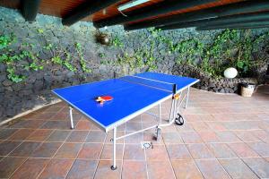 a blue ping pong table sitting on a patio at CONCHA - Sonnenbett, Sauna, traumhafter Meerblick, beheizter Pool, Billiard, Tischtennis in La Asomada