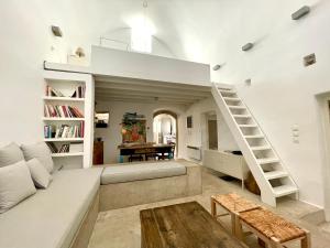 a large living room with a couch and a staircase at 19th Century Vaulted Villa in Kythira
