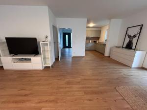 un salon vide avec une télévision à écran plat dans l'établissement Ludwig1, à Kindsbach