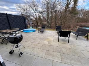 une terrasse avec des chaises, un barbecue et une piscine dans l'établissement Ludwig1, à Kindsbach