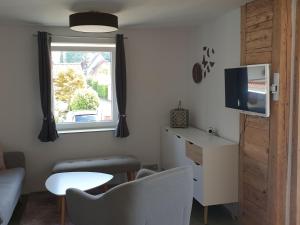 a small living room with a table and a tv at Ferienwohnung Jakob in Kressbronn am Bodensee
