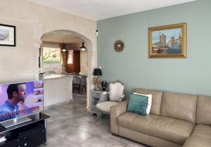 a living room with a couch and a tv and a kitchen at Villa Marguerite in Coutras