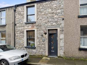 a white car parked in front of a stone house at Lovely 2 Bed With Pool Table Ulverston - Pass the Keys in Ulverston