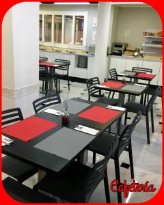 a dining room with black tables and red napkins at Hotel Albatros in Gandía