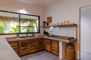 a kitchen with a sink and a large window at Casa Malia Siargao in General Luna