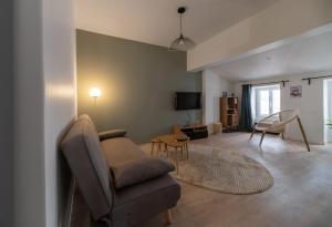 a living room with a couch and a chair at L'Evasion Urbaine #Hypercentre#Confort in Clermont-Ferrand