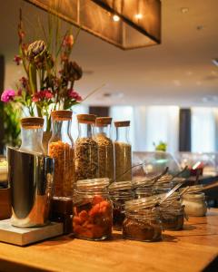 a table with several glass vases filled with food at Boston Hotel HH in Hamburg