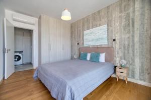 a bedroom with a large bed with blue pillows at Avenue 202 1 BED in Paphos +8 photos