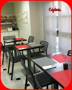 a dining room with tables and chairs with red napkins at Hotel Albatros in Gandía